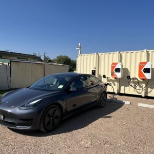 Shiny black Tesla charging close up