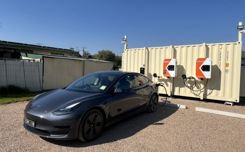 Shiny black Tesla charging close up